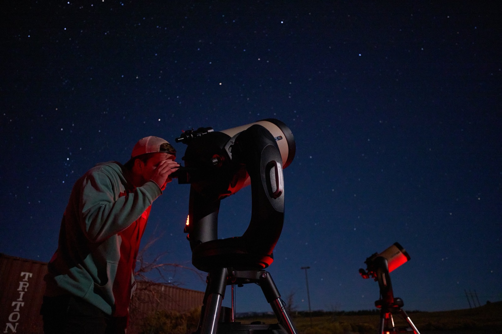 Tour guest looking through a telescope eyepiece under a starry sky near Bryce Canyon